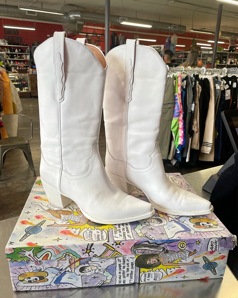 All white Jeffrey Campbell western boots sit on top of their box