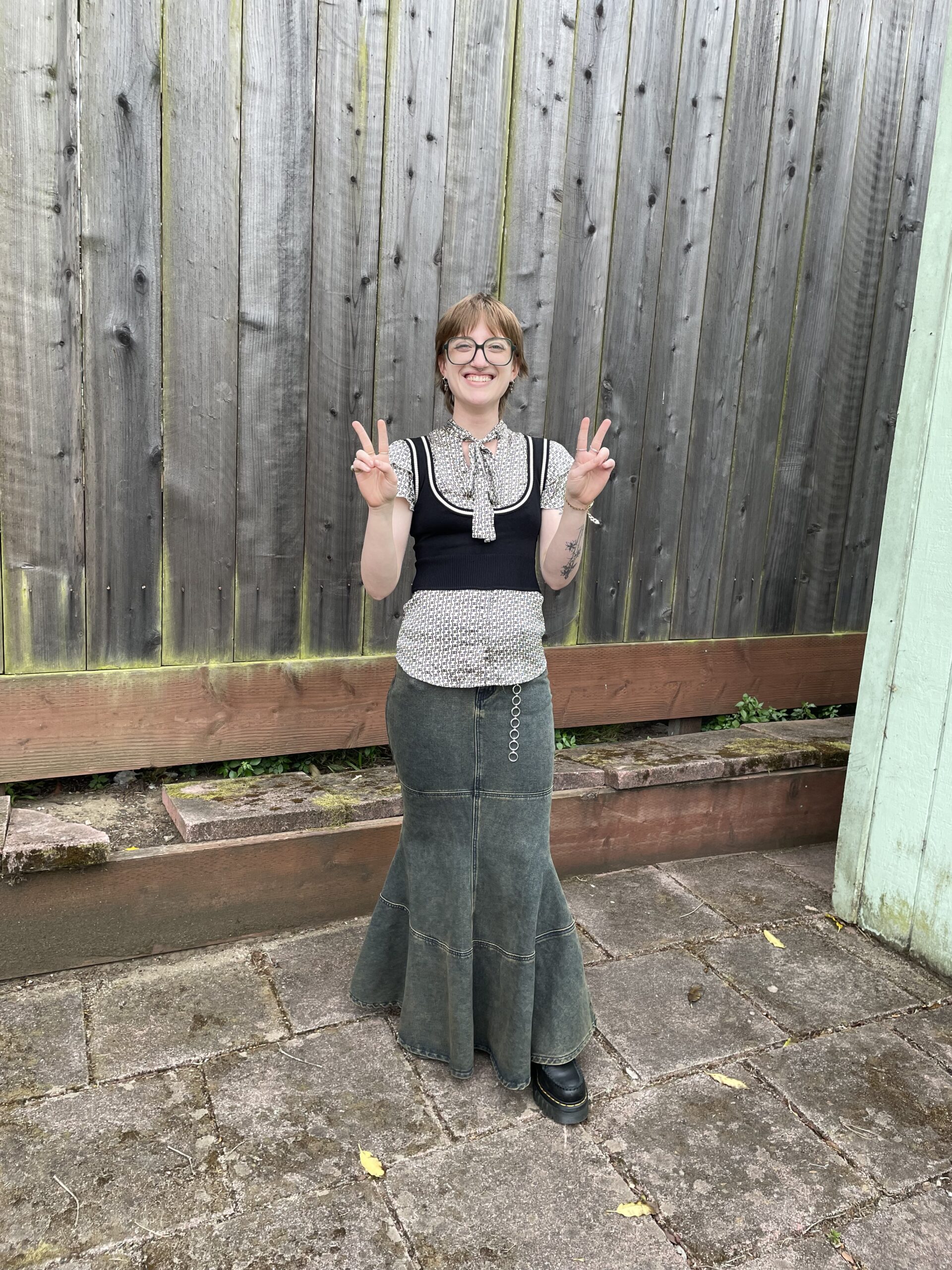 Employee Izzy holding up double peace signs