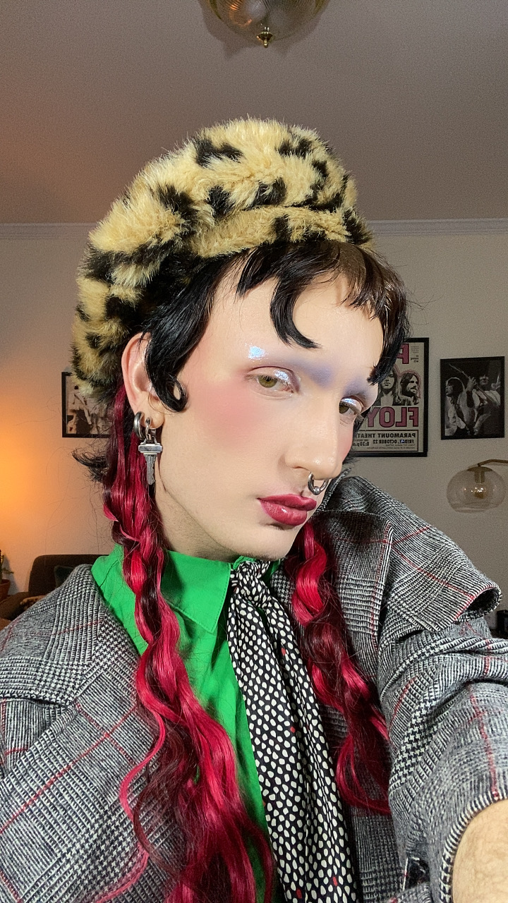 Employee Elio in suit and makeup with fur hat