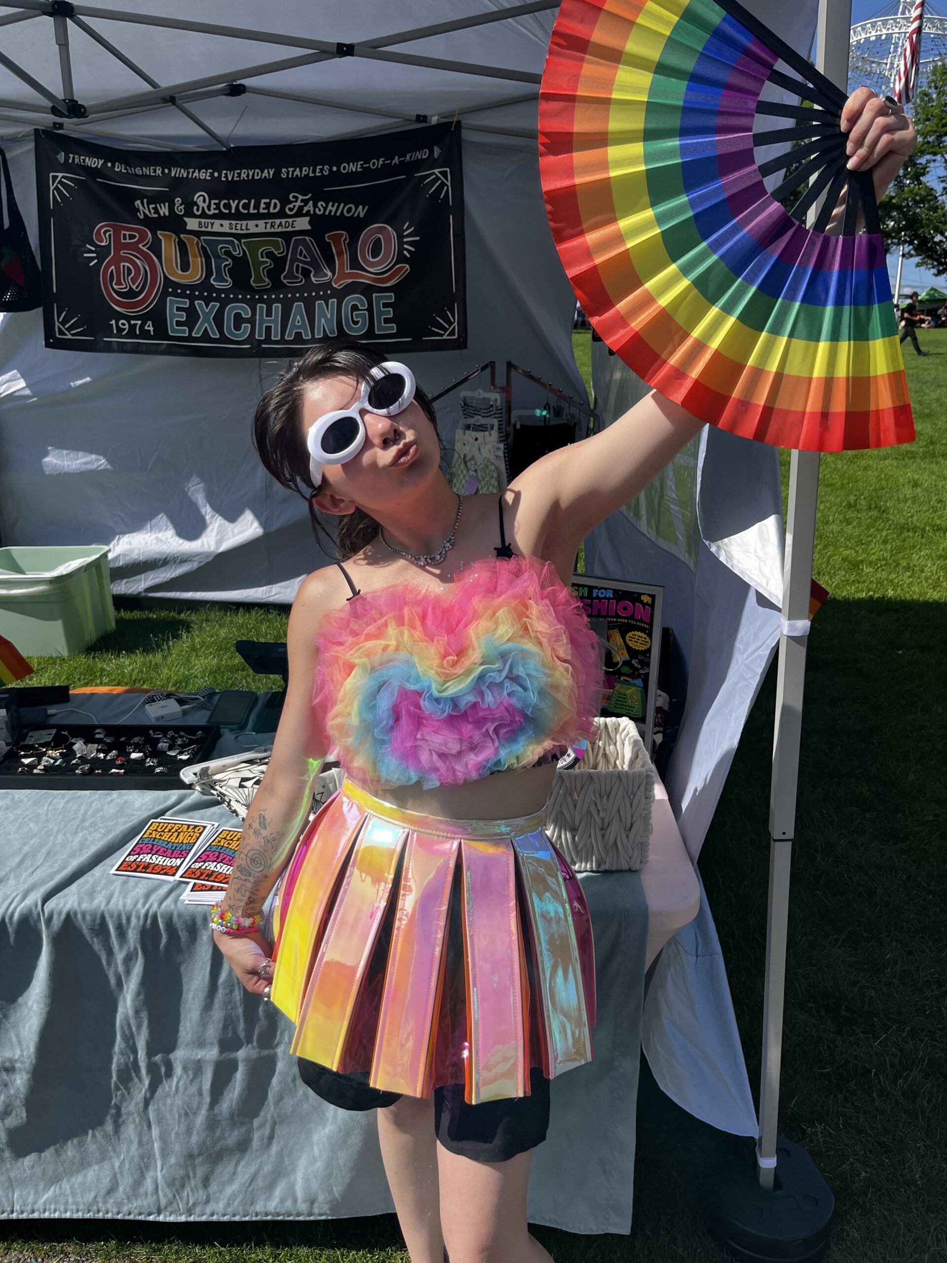 Employee Gwen in rainbow outfit with rainbow fan