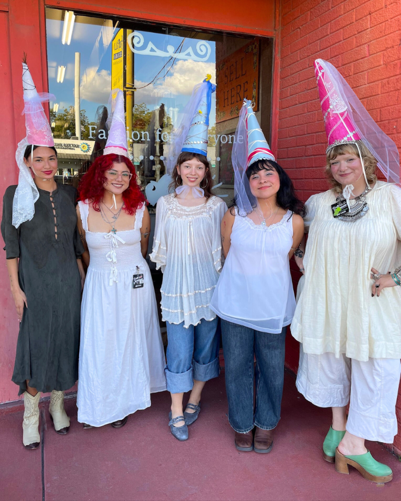 Group of girls in flowy linen clothes and pointed princess hats