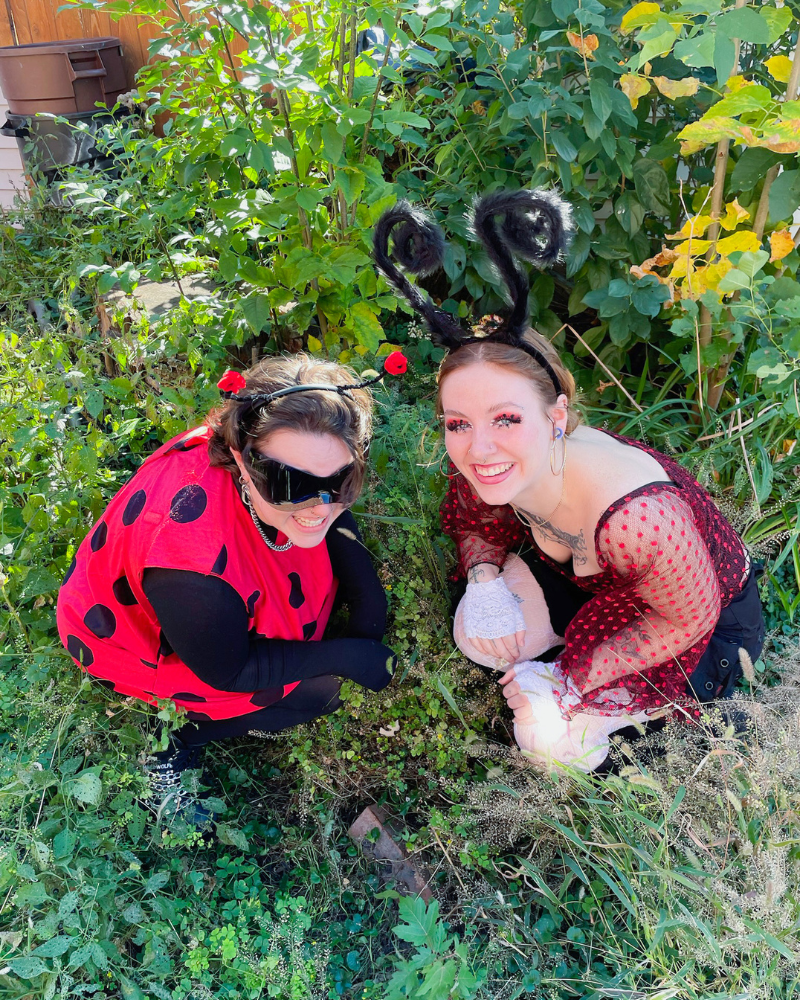 Two Buffalo Employees in polka dots with bug antennae crouching in grassy area.